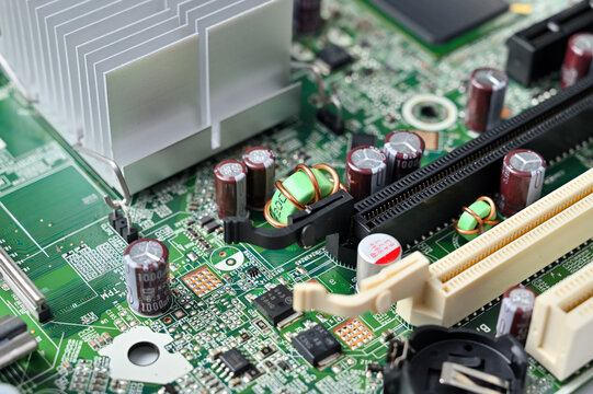 Close-up view of a complex green circuit board with various electronic components and a heatsink