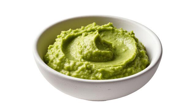 Isolated fresh creamy green avocado dip or guacamole in a white bowl, ready for serving.
