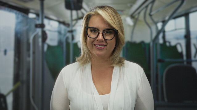 Young blonde woman scrunches lips, tilts head and raises eyebrow inside a bus on a busy street; playfulness.