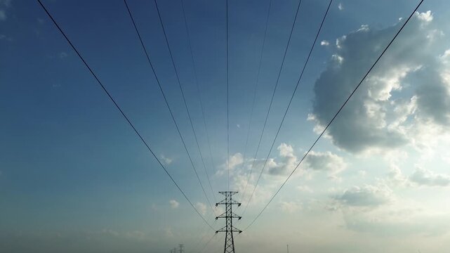 Aerial drone footage of high voltage transmission towers and power lines during perfect natural light afternoon with dynamic movement and diverse angles for energy infrastructure visuals.