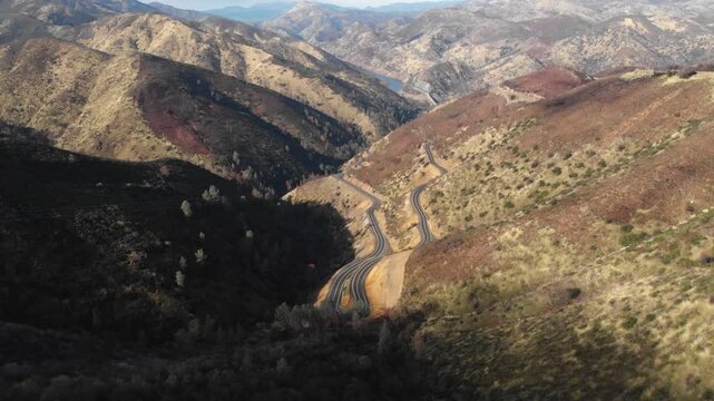 Aerial drone view of winding road through mountain valley near Yosemite, California