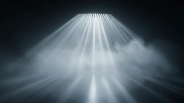 Dramatic beams of light pierce through a thick layer of fog and darkness