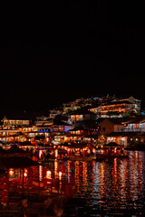 Obraz premium Chinese Style Lakeside Village Illuminated with Warm Lantern Lights Reflecting on Dark Lake at Night, Ban Rak Thai