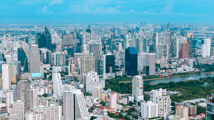 Aerial View of Bangkok City Skyline with Dense Skyscrapers and Green Canal Park in Daytime, Thailand Capital City