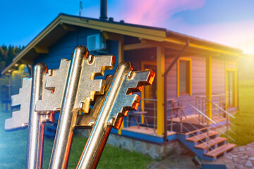 Real estate services, Property sale highlights house ownership with keys in focus near a private home. Residential housing, mortgage deals, home purchase, investment property.