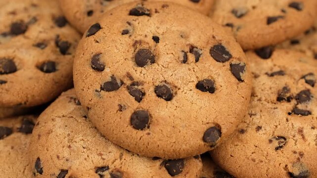 Heap of traditional sweet chocolate chip cookies close up, rotation