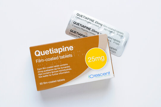 Quetiapine film-coated tablets or pills 25mg packaging with foil blister pack top view on white background. Quetiapine  is an atypical antipsychotic used to treat schizophrenia, bipolar disorder