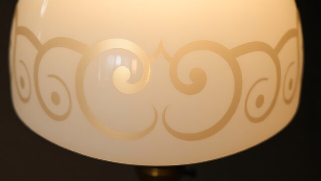anhydrite. Art Nouveau 'S' curve pattern on an opal glass lampshade, soft glow. real-estate listings, architecture portfolios, designed for real-estate listing and luxury residence showcases.
