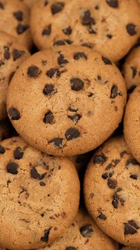 Heap of sweet chocolate chip cookies close up, rotation