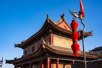 Obraz premium Old wall in Xian, China with traditional towers and red lanterns