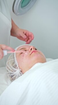 Client enjoys a high-frequency electrotherapy session for skin healing and blemish removal in a professional beauty salon setting.