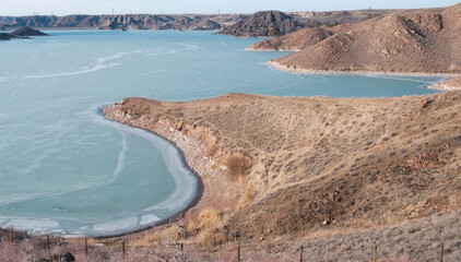 High angle view of Kapchagay reservoir coastline with turquoise water and arid hills in winter. Versatile background for travel, environmental conservation, and regional geography themes © Lana Kray