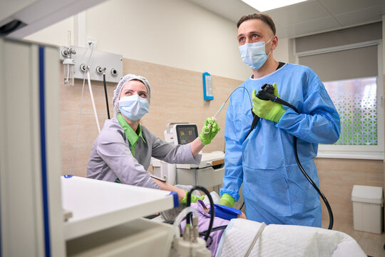 Doctor and nurse performing endoscopy in hospital room