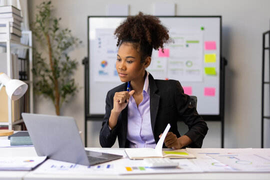 Young businesswoman working with laptop and documents in office.