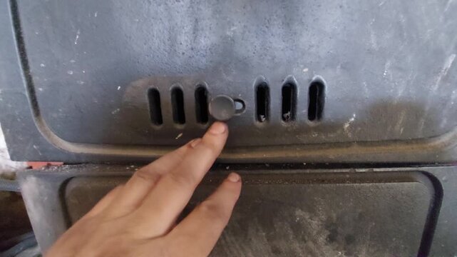 Adjusting the air intake slider on a wood-burning boiler