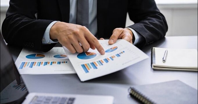 Businessman analyzing charts and graphs at desk