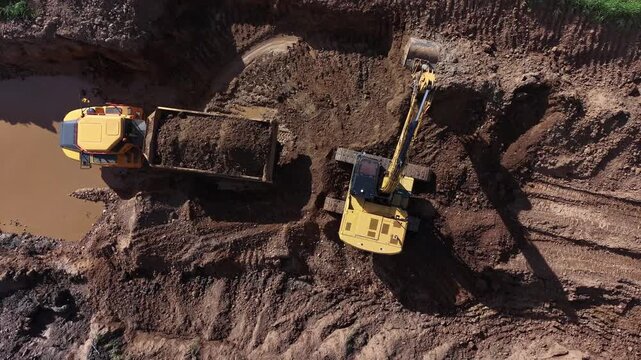 El cierre de la jornada: excavadora vuelca la &uacute;ltima palada y el dumper se aleja lleno en la cantera