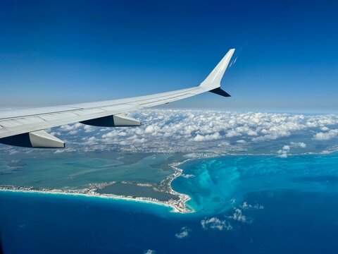 View from airplane window of airplane wing above Mexican coastline including Cancun hotel zone in Quintana Roo, Mexico