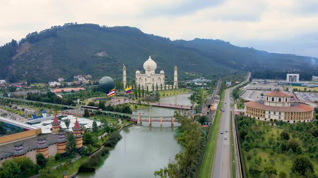 Stunning aerial shot of Jaime Duque Park featuring a Taj Mahal replica surrounded by lush trees. A river flows alongside the park