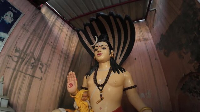 Traditional deity sculpture of Lord Shiva sitting on a tiger skin with a snake canopy.
Capturing the divine and spiritual essence of Hindu religious art and temple worship.
