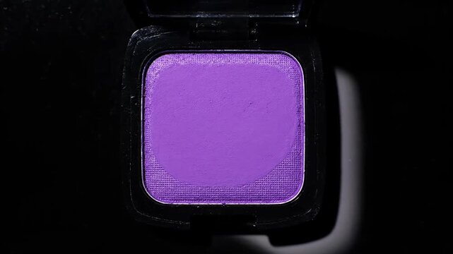 Bright purple matte eyeshadow pan in black makeup compact