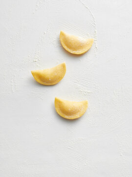 Three pieces of fresh pasta dough arranged on a clean surface. Ideal for use in cooking blogs, recipe websites, or culinary magazines focused on Italian cuisine