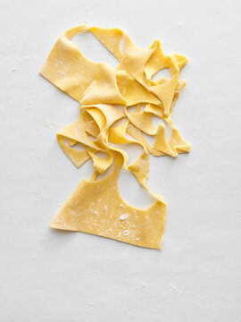 The image shows freshly prepared pasta dough laid out on a flat surface, highlighting its texture and color. This can be used for recipe blogs, cooking classes, and restaurant menus