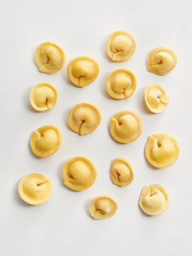 The image showcases a collection of freshly made tortellini arranged on a light background. Ideal for restaurant menus, food blogs, and culinary social media content