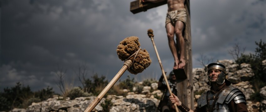 Close-up of a sponge on a reed offered to Jesus on the cross. Roman soldier standing guard at the crucifixion on Golgotha. Good Friday biblical scene