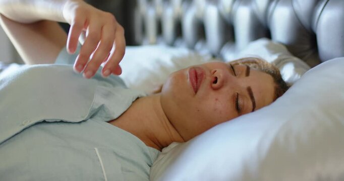 Adult African American woman in bed stirring frowning raising hand holding forehead easing headache
