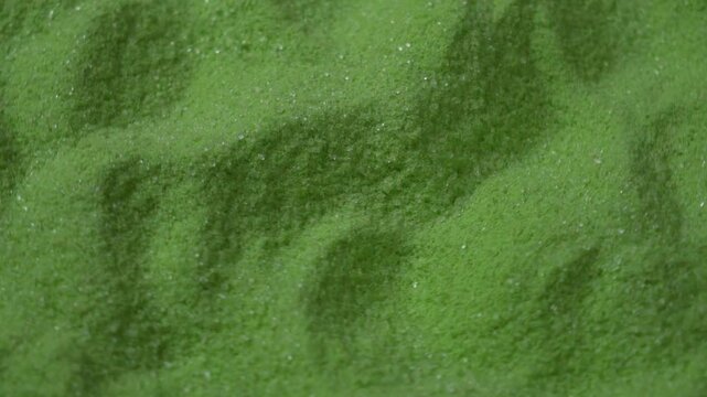 Rotating macro texture of fine matcha green tea powder as background