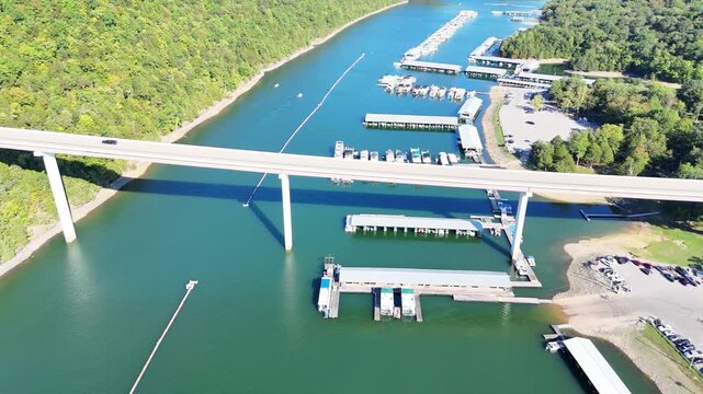 Aerial View of the Lakeside Sunset Marina Resort on Dale Hollow Lake With Highway 111 Bridge, Boats and Forested Shoreline, Calm Water on a Sunny Day, Monroe, Tennessee, USA.