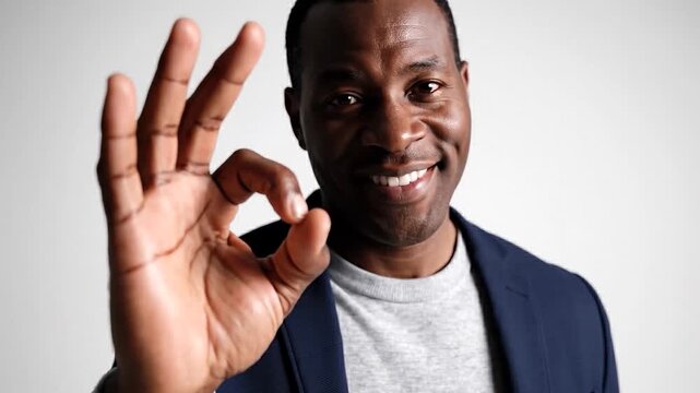 Confident businessman showing okay gesture in professional attire