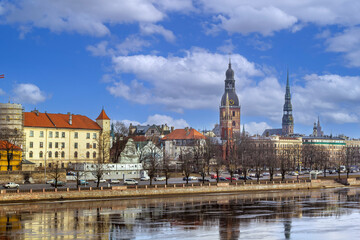 Fototapeta premium Daylight panoramic view of Old Riga city skyline from Daugava river, Latvia. Historic church spires and medieval buildings