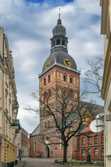 Fototapeta premium View of Riga Cathedral tower and small square on a cloudy February day, Latvia. Historic Lutheran cathedral and city street