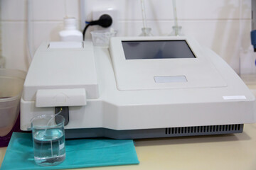 Fototapeta premium A biochemical analyzer is on the table in the laboratory. Horizontal shot.