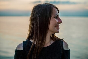 Side profile portrait of smiling young woman at sunset © Bohdan