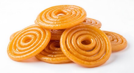 Fototapeta premium A close up view of several fresh golden indian jalebi sweets stacked on a plain white background