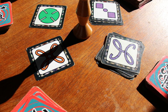 Items of Jungle Speed board game on green baize table. Jungle Speed is a card game