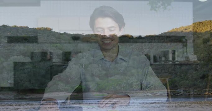 Vertical video: Recording man in light shirt reading notes and gesturing in studio, coastal overlay