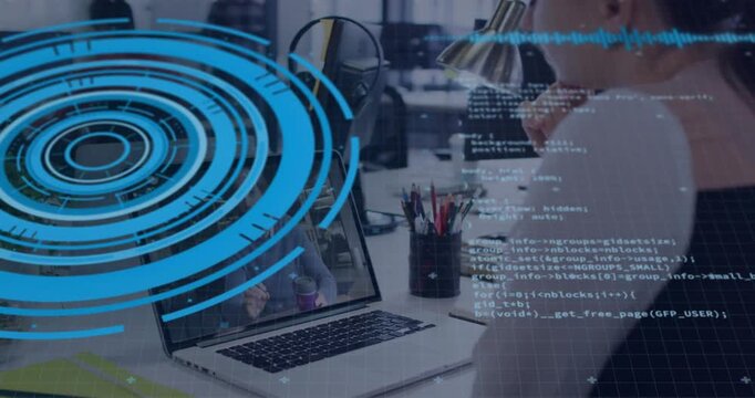 Vertical video: Blue HUD appearing man wearing vest studying laptop at office watching code overlay