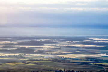 Naklejka premium Panoramic view of morning mist covering a vast valley at sunrise