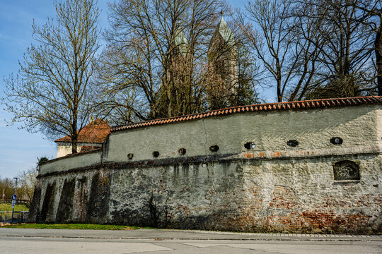 Mauer und Kircht&uuml;rme eines alten Friedhofs in Deutschland an einem sonnigen Tag