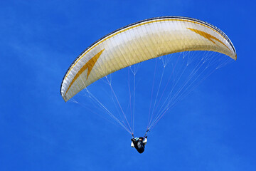 Paraglider flying in a blue sky