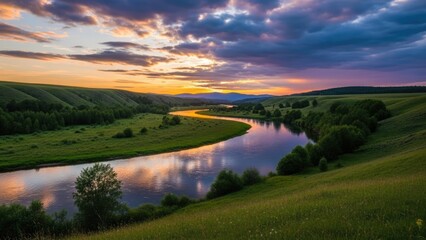 Fototapeta premium A serene landscape of a winding river at sunset with green hills and trees