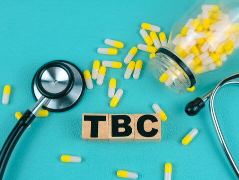 Concept word TBC on wooden blocks isolated - on light green background