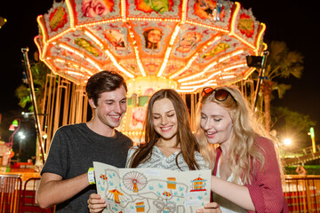 Friends enjoying amusement park map. © Rawpixel.com