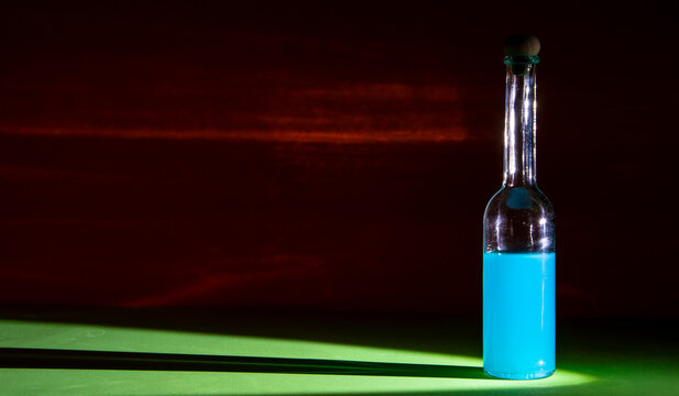 licor Blue Cura&ccedil;ao, botella peque&ntilde;a de licor azul con 
fondo rojo 