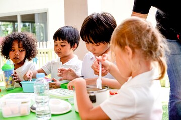 Children enjoying lunch outdoors together.