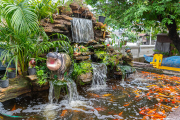 Naklejka premium Waterfall in a little garden on a park of Bangkok, Thailand